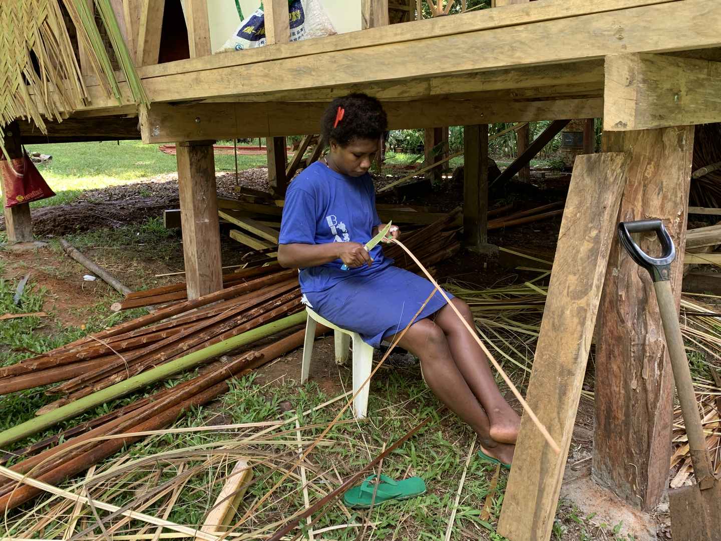 Woman cutting bamboo for weaving